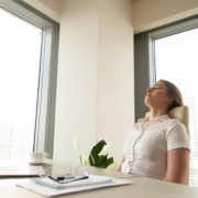 Businesswoman has deep relaxation at workplace. Relaxed woman sitting with closed eyes at the desk with laptop in office. Short recovering sleep on work. Minute break for increasing productivity